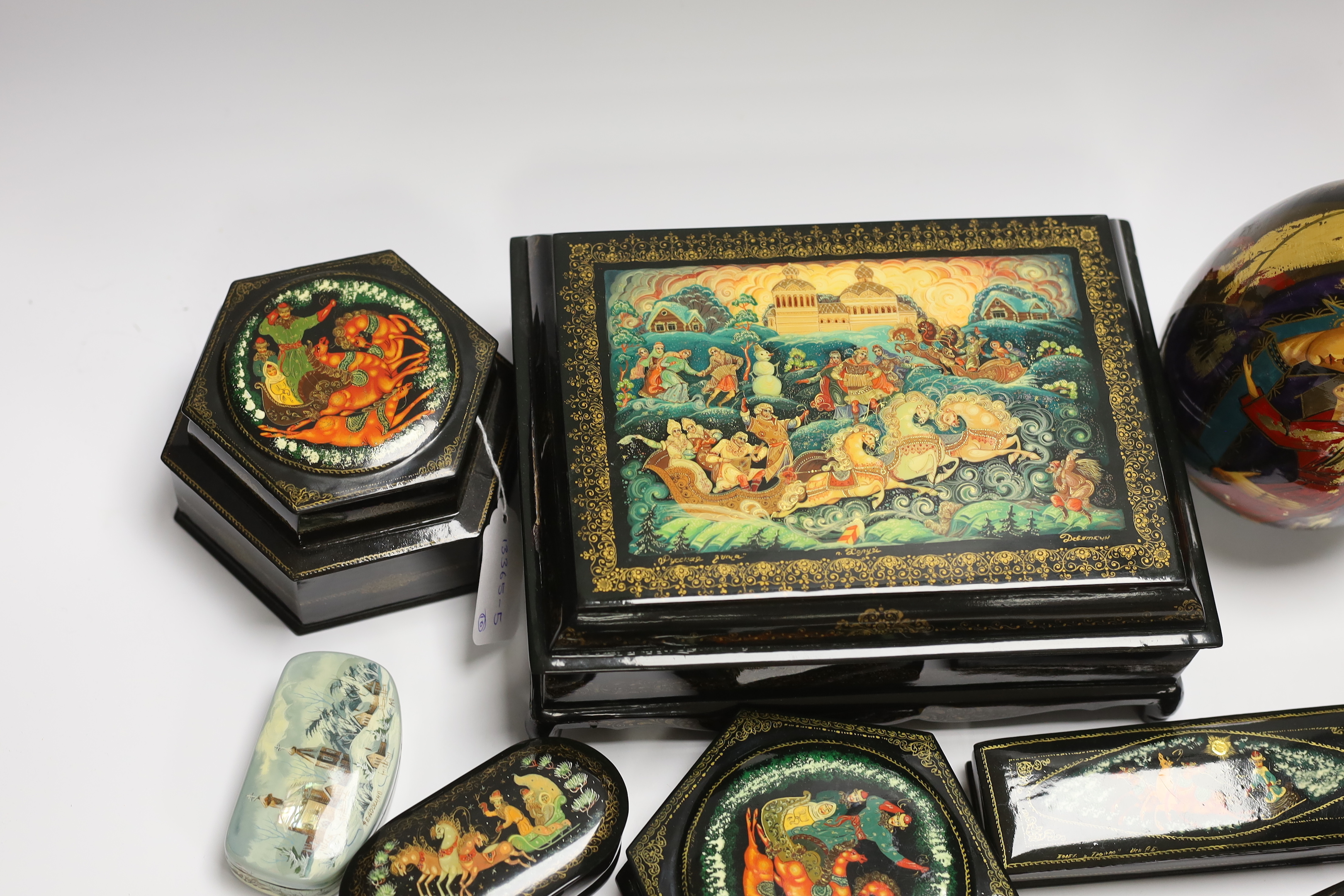 Nine Russian lacquer boxes including a two section hexagonal example and an egg, largest 25cm wide